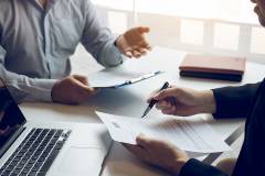 Foto: Personen besprechen Akten