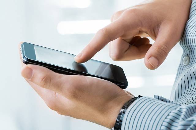 Foto: Person tippt auf Mobiltelefon